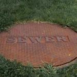 sewer manhole cover in grass