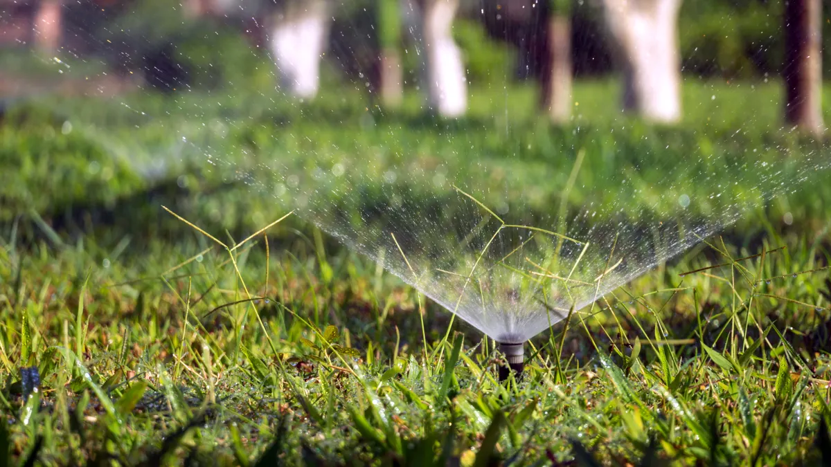 sprinkler spraying water across grass
